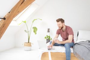 Man op laptop op zolderkamer
