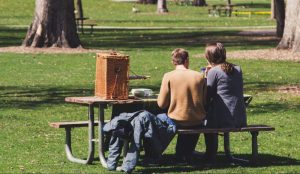 Twee mensen in een park aan een picknicktafel