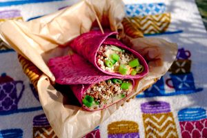 Vegetarische groente burrito's in een bietenwrap, geserveerd in een robuust mandje