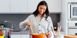 vrouw roert in pan op fornuis