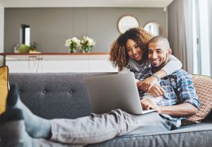 man en vrouw op bank achter computer
