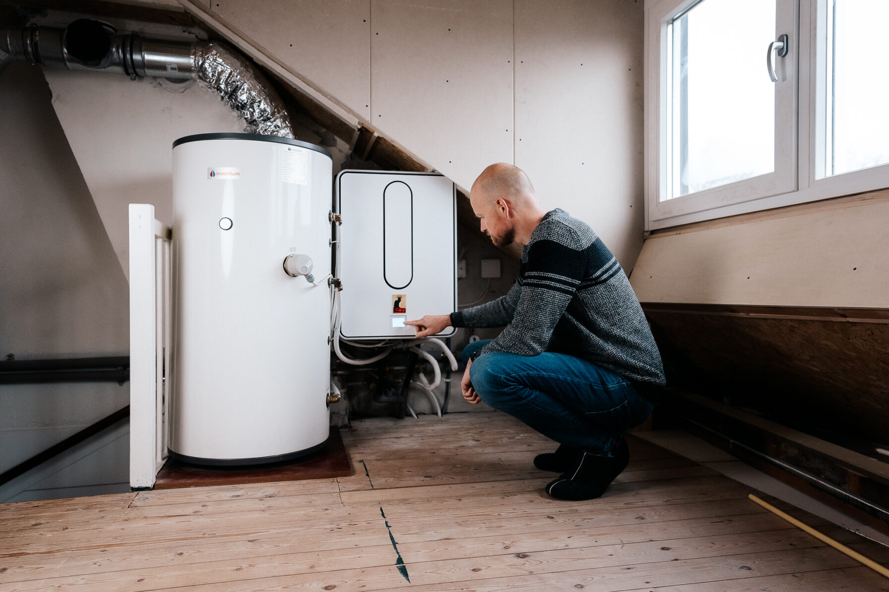 Man checkt zijn warmtepomp op zolder