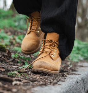 Gele schoenen die lopen door de aarde in een stadspark