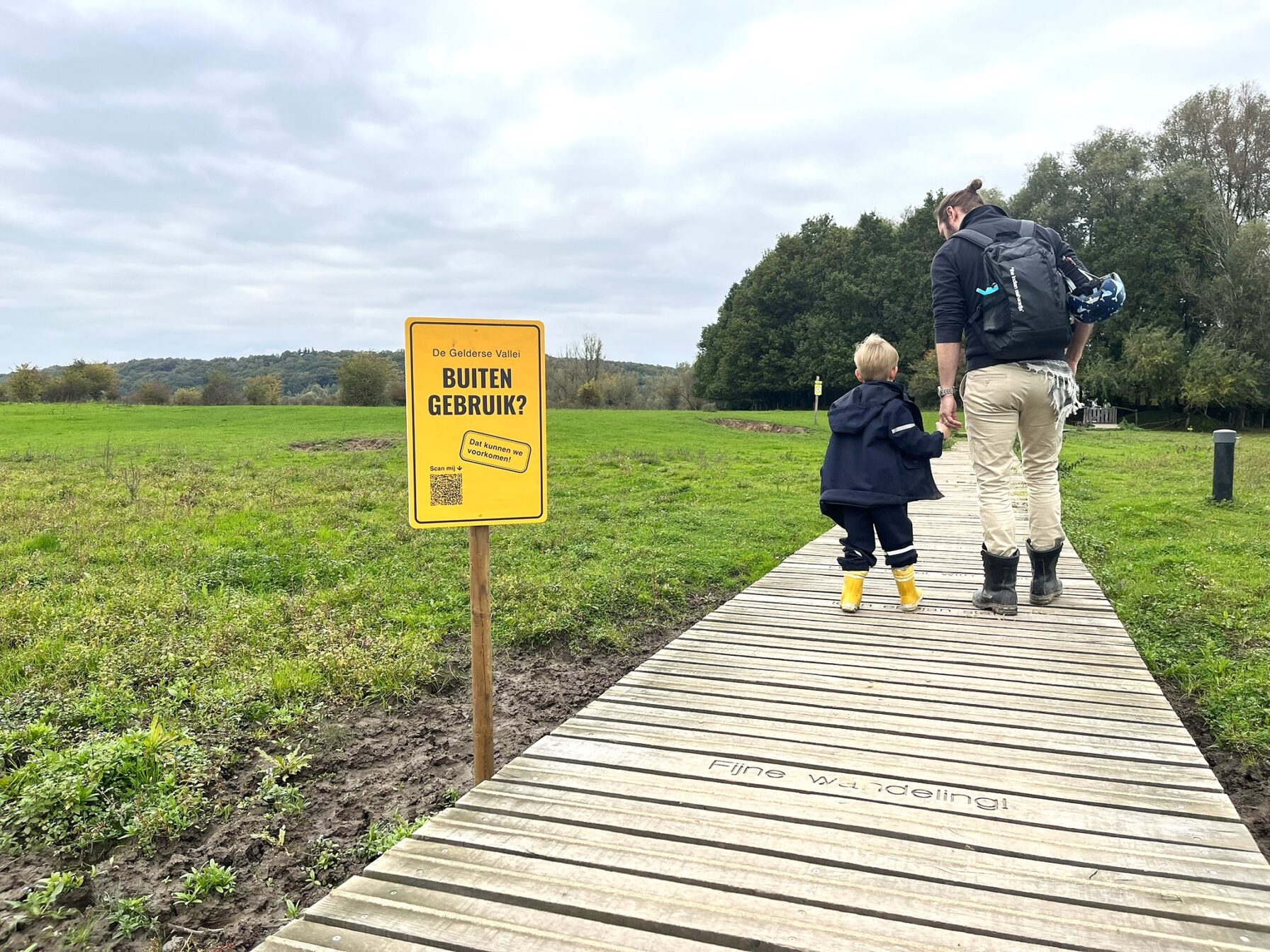 Foto van man met kind in natuurgebied, naast bord met 'Dit natuurgebied buiten gebruik? Dat moeten we voorkomen'
