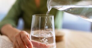 Vrouw giet water in een glas
