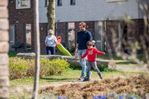 Ouder met kind buiten op straat aan het skeleren