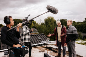 Eddy Zoëy met filmploeg op een dak van een huis