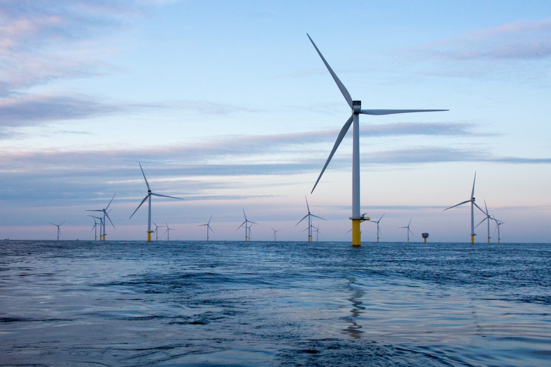 windmolens op zee bij zonsondergang