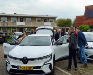elektrische deelauto wordt bekeken door deelnemers auto van de straat