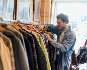 Man zoekt kleding uit in een winkel