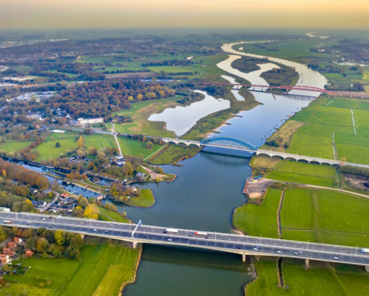 bovenaanzicht van nederlandse rivier met brug en wegen