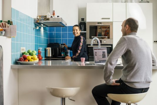 Twee personen aan een kookeiland in een keuken met een inductieplaat
