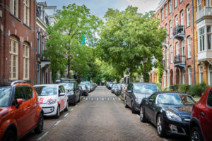Amsterdam, Netherlands - August 29 2020: Parked cars line Gijsbrecht Van Aemstelstraat on August 29 in Amsterdam. City street with traditional Dutch architecture linking Amstel river to Wibautstraat.