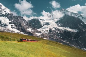 rode trein rijdt door besneeuwd berglandschap
