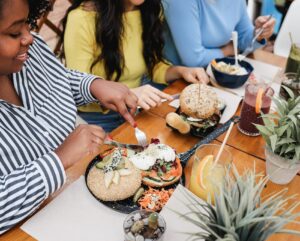 Drie personen eten een vegetarisch gerecht in een restaurant